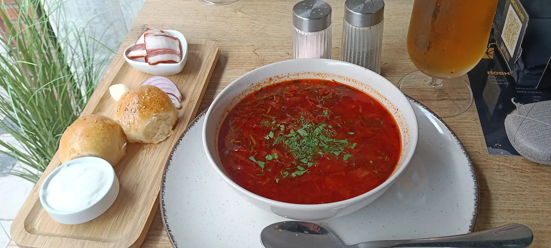 Un plato de borsch con eneldo, pan y salo